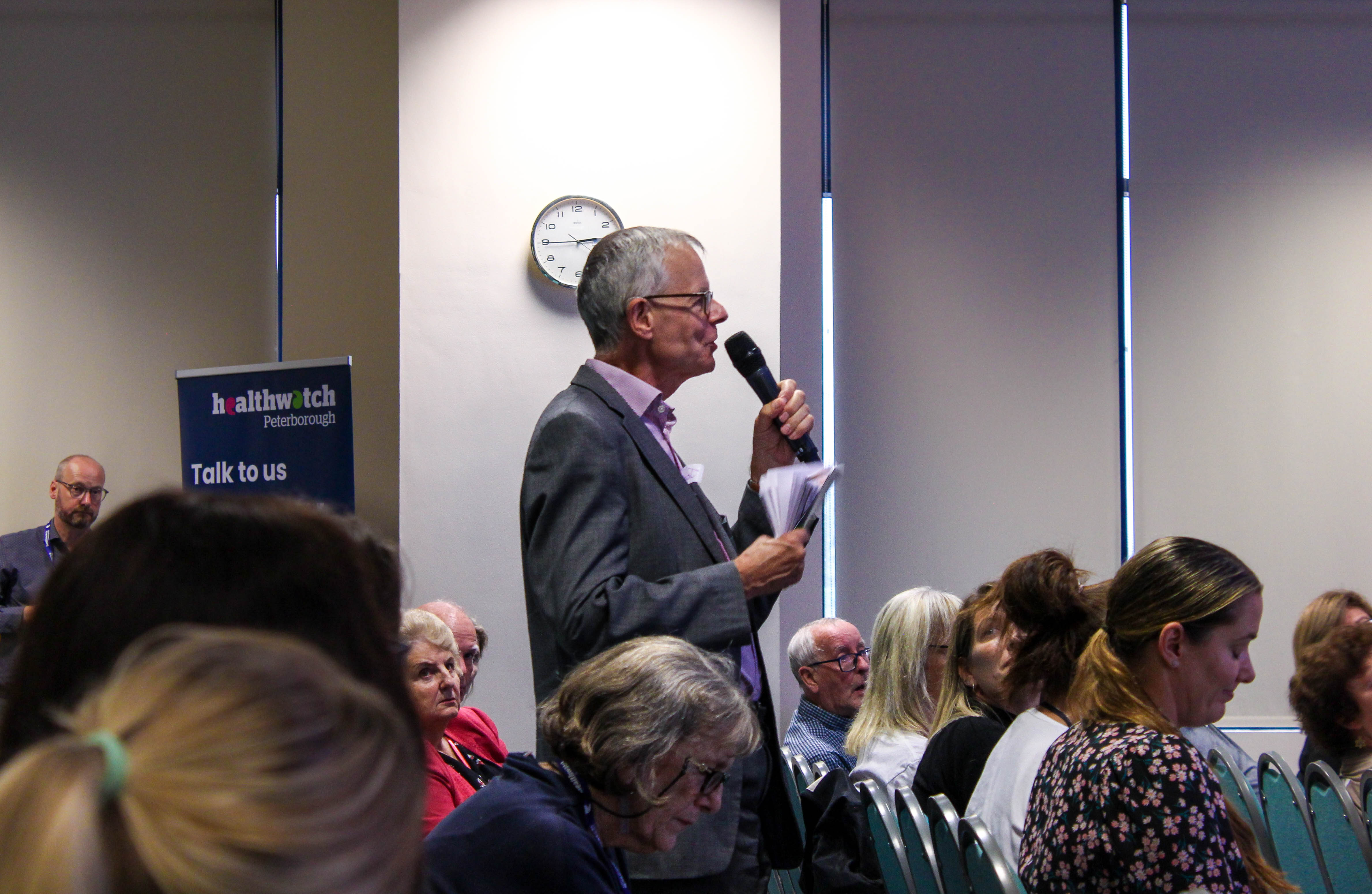 A member of our Question Time audience standing with a hand held microphone and asking a question to the panel