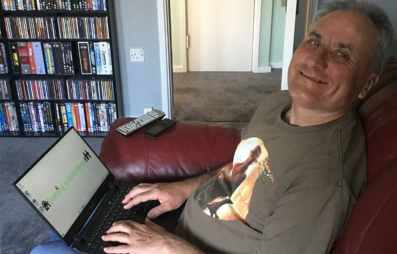 man sitting next to a laptop