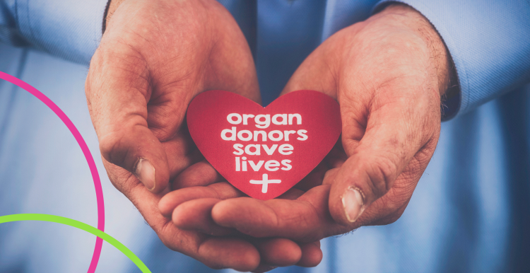 A mans hands holding a heart in his hands with organ donors save lives written on it.