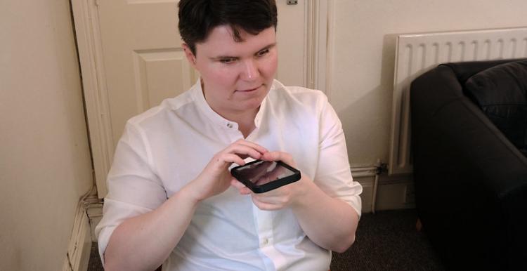 Blind person listens to message on mobile phone device
