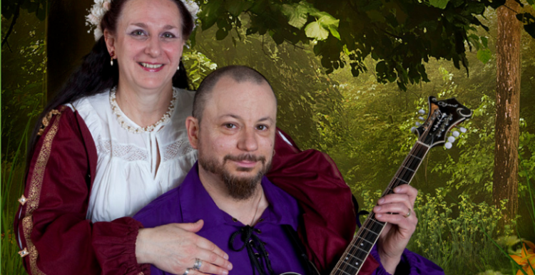 woman in medieval dress and man playing musical instrument