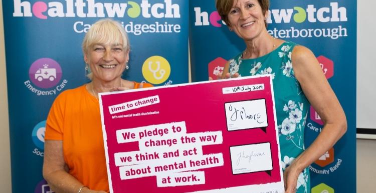 Two women holding a mental health support pledge 