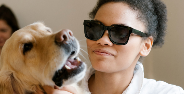 woman wearing dark glasses with a guide dog