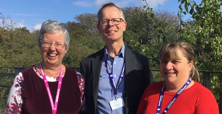 three people smiling at camera