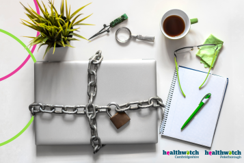 A photo of a laptop chained and locked with a padlock, next to a plant, cup of coffee and a notepad with pen.