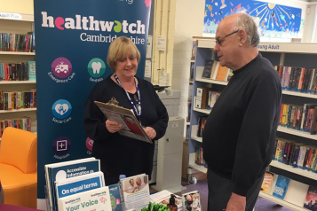 Healthwatch volunteer Pam listening to a member of the public in a library
