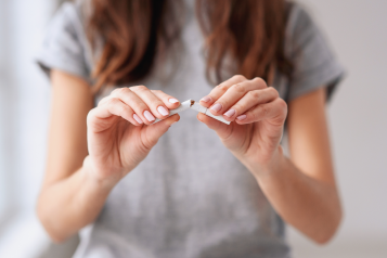 A woman snapping a cigarette in half