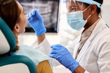 Image of a dentist performing a checkup on a patient