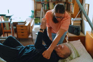 older man being hoisted at home by carer