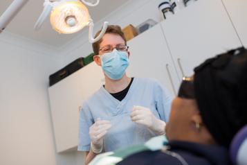 Dentist treating a patient in a treatment room