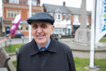 Older man standing outside looking at camera 