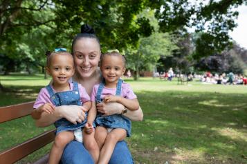 Woman with twin baby girls smiling at the camera