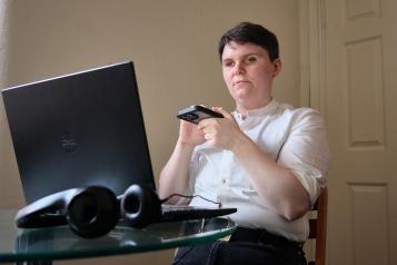 Visually impaired person using a screen reader to access information from a laptop computer