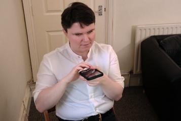 Blind person listens to message on mobile phone device 