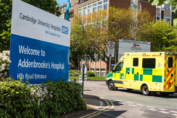 Entrance to Cambridge University Hospitals with ambulance driving in