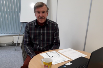 man sitting next to a laptop