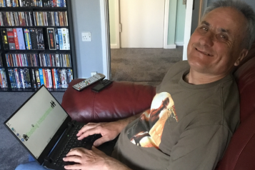 man sitting next to a laptop