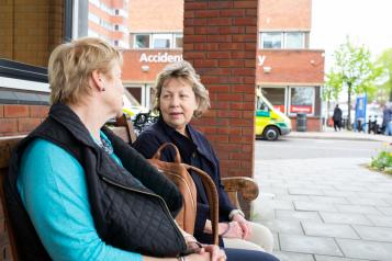 two women talking outside a hospital