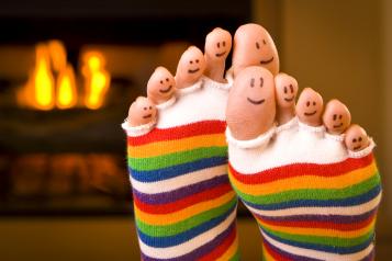 Picture shows feet in socks in front of a fire