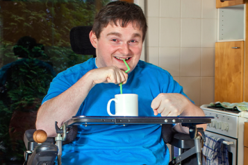 Man in wheelchair inside - having a drink