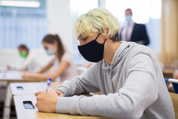 Boy in classroom wearing face covering