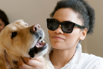 woman wearing dark glasses with a guide dog