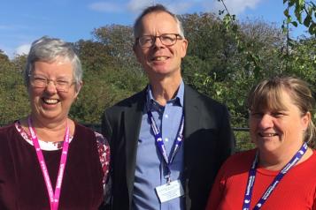 three people smiling at camera