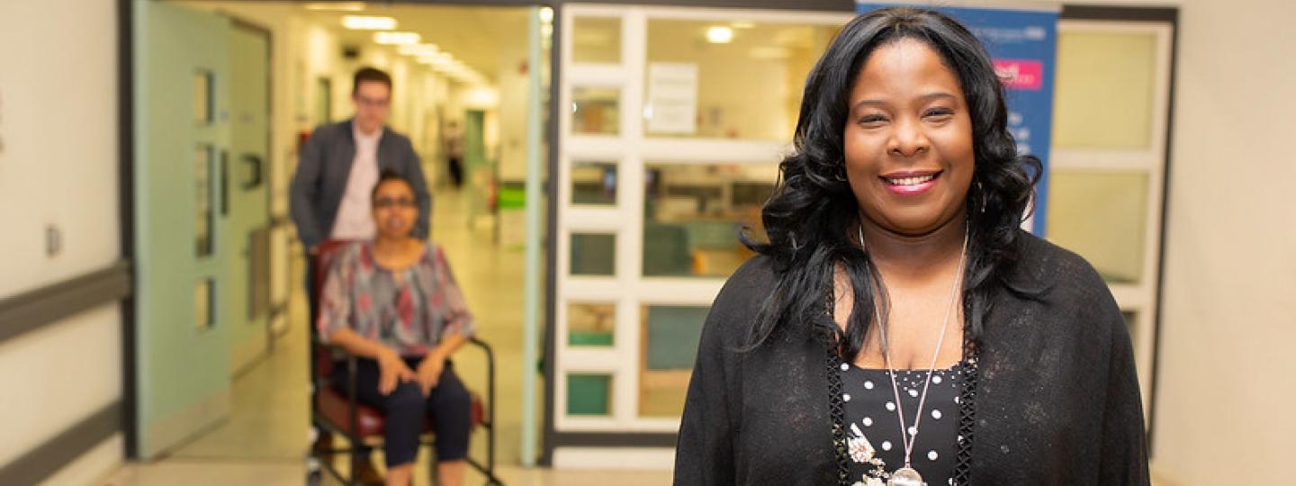 woman smiling into camera in hospital corridor