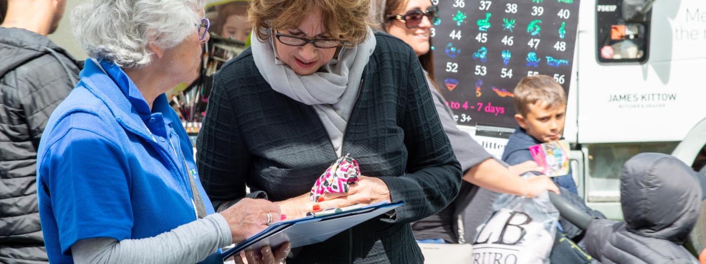 Healthwatch volunteer writing on a clipboard