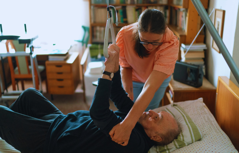 older man being hoisted at home by carer