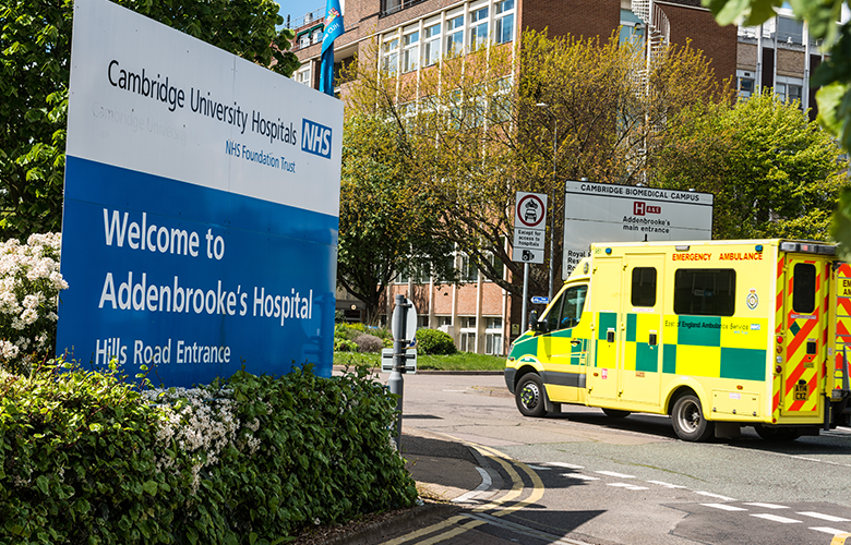 Entrance to Cambridge University Hospitals with ambulance driving in