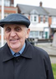 Older man standing outside looking at camera 