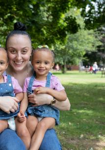 Woman with twin baby girls smiling at the camera