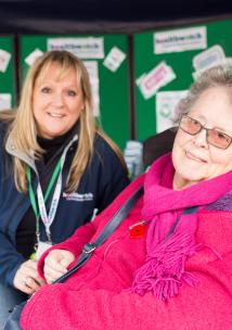 Healthwatch Volunteer at a community event speaking to a woman in a wheelchair Healthwatch Volunteer at a community event speaking to a woman in a wheelchair