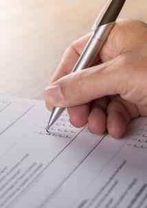 Help us find out what local people think about our service Person's hand completing a questionnaire